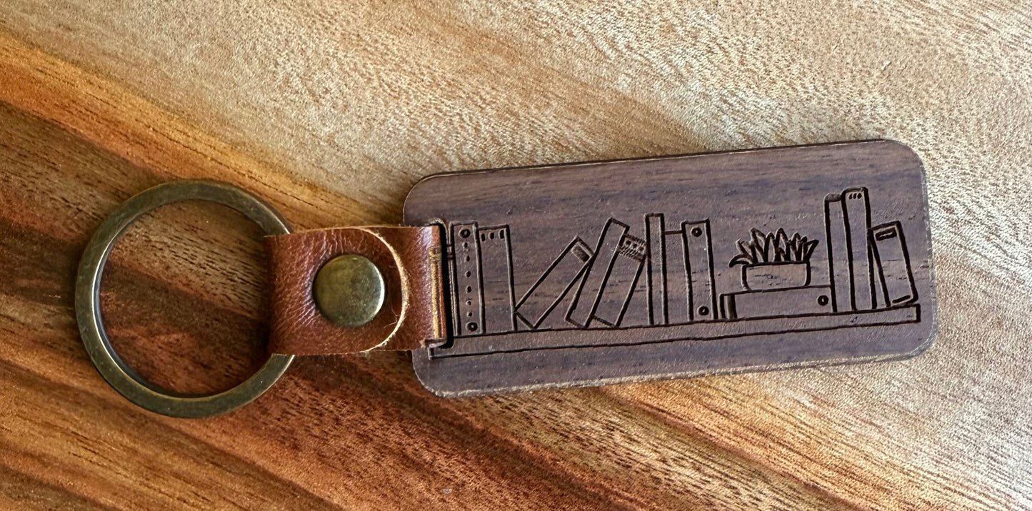 Wooden keychain with bookshelf design on a wooden surface
