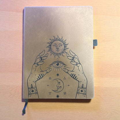 Notebook with celestial design on a wooden surface