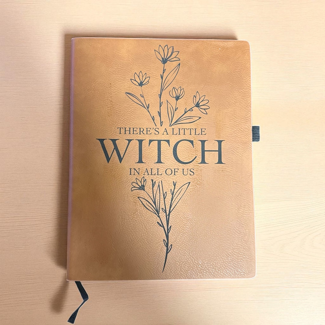 Brown notebook with floral design and text on a wooden surface