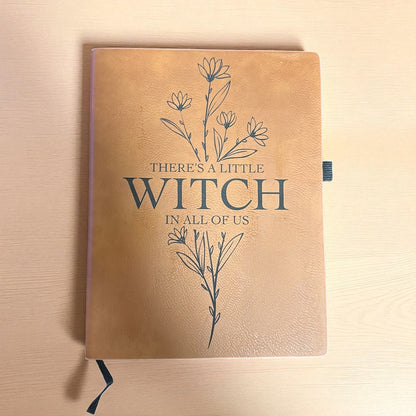 Brown notebook with floral design and text on a wooden surface