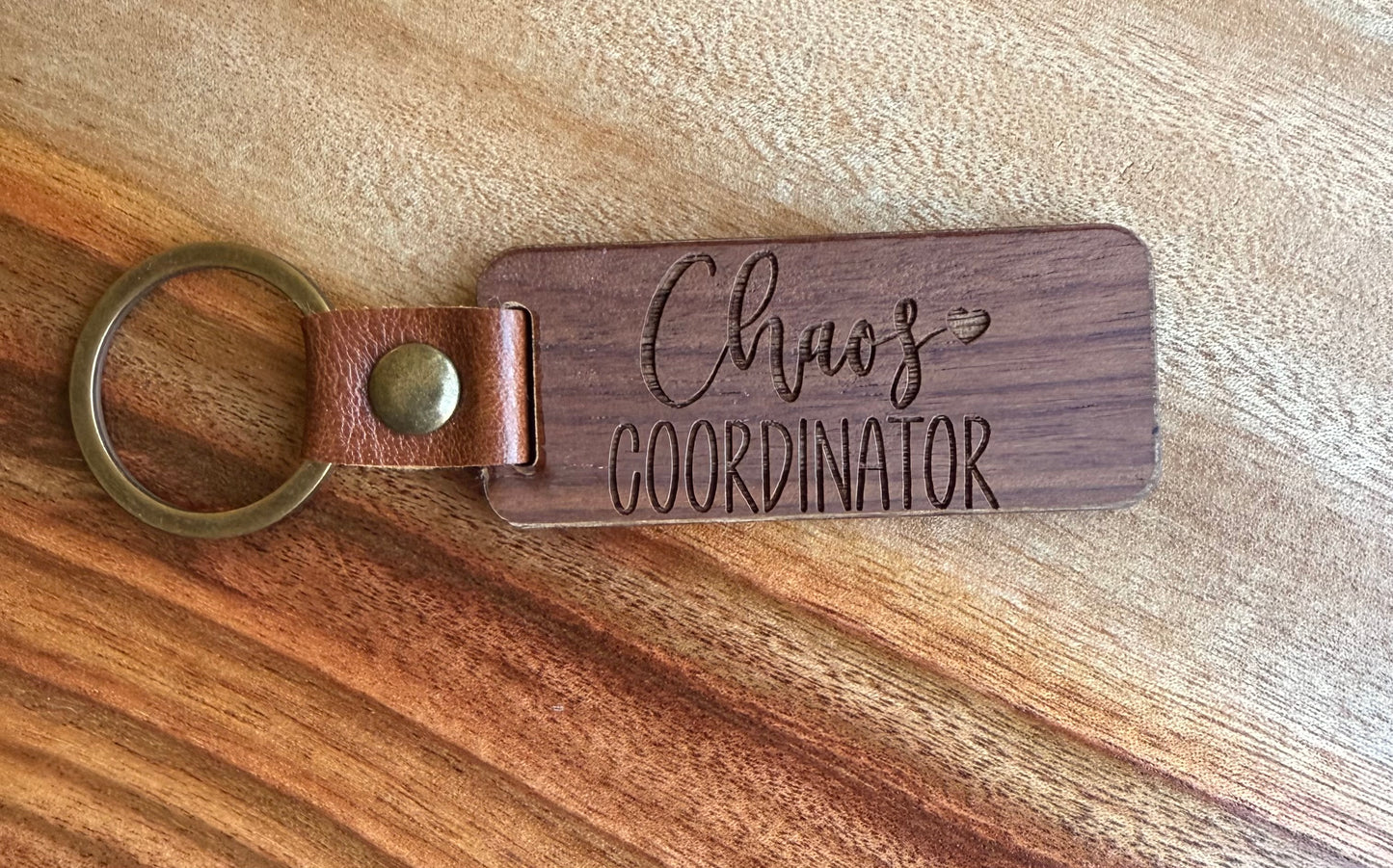 Wooden keychain with 'Chaos Coordinator' engraving on a wooden surface