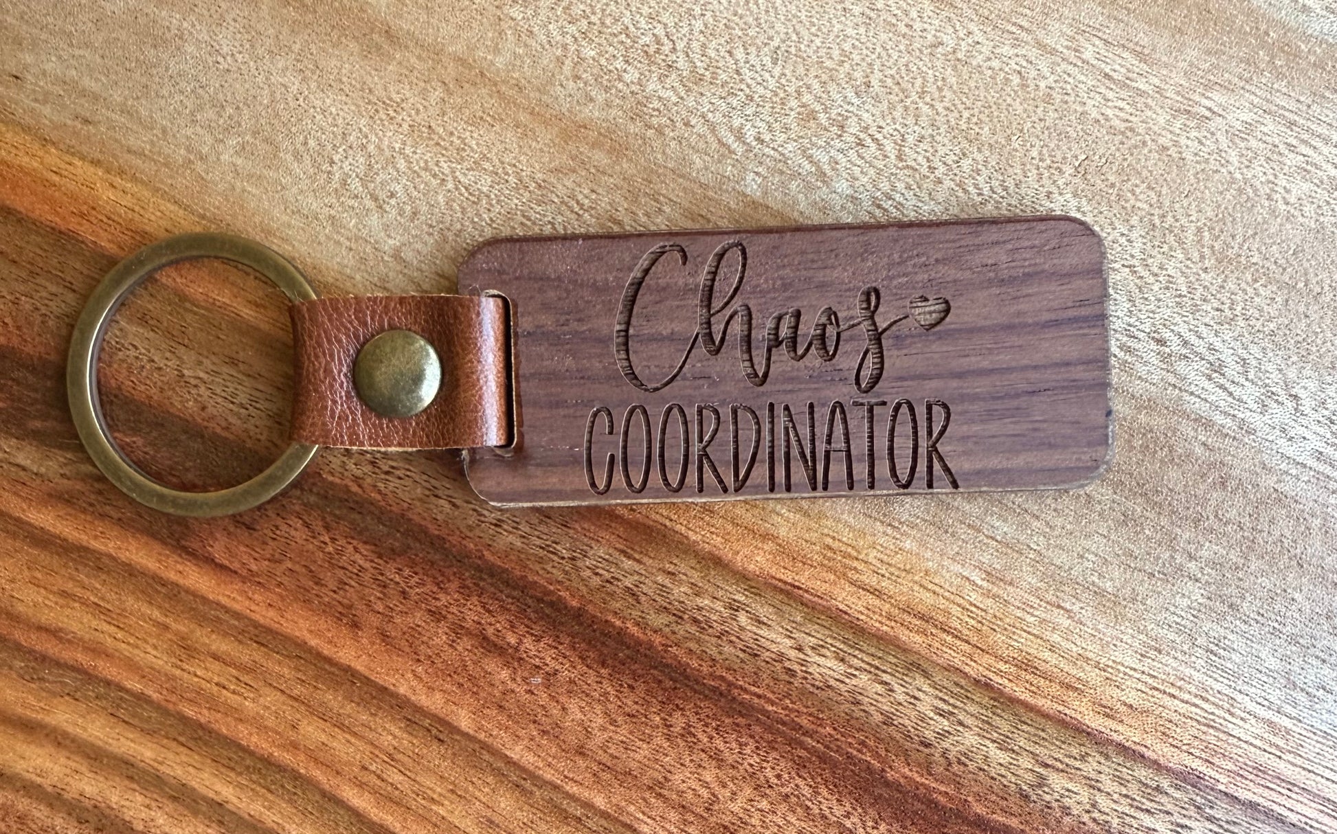 Wooden keychain with 'Chaos Coordinator' engraving on a wooden surface