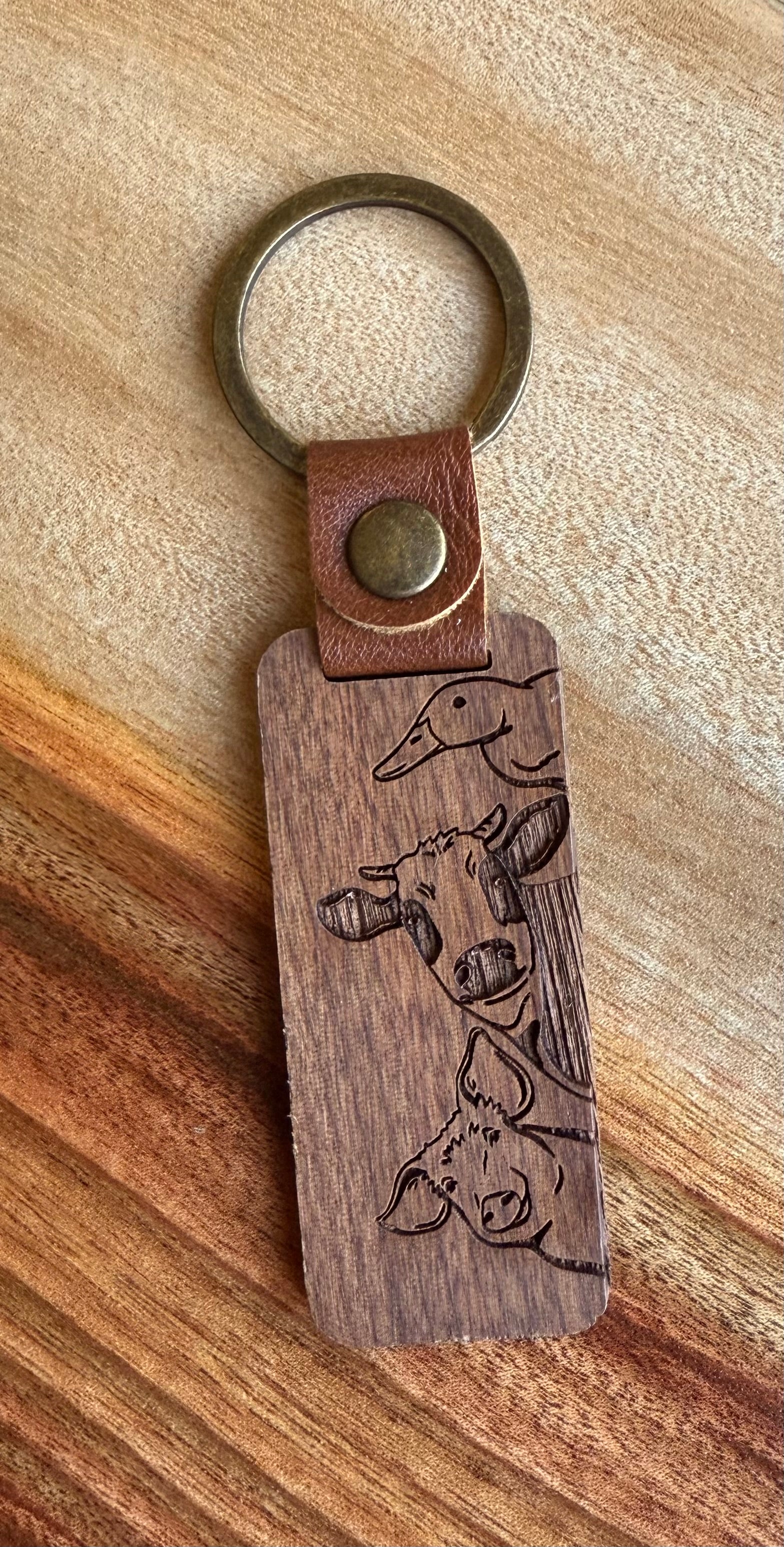 Wooden keychain with engraved design on a wooden surface