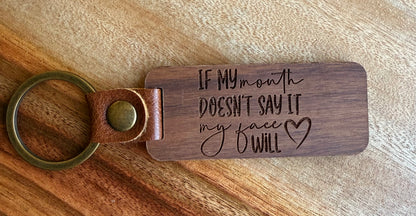 Wooden keychain with engraved text on a wooden surface