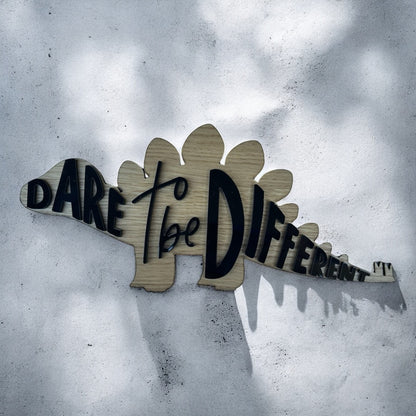 wood stegosaurs outline with the words dare to be different in acrylic