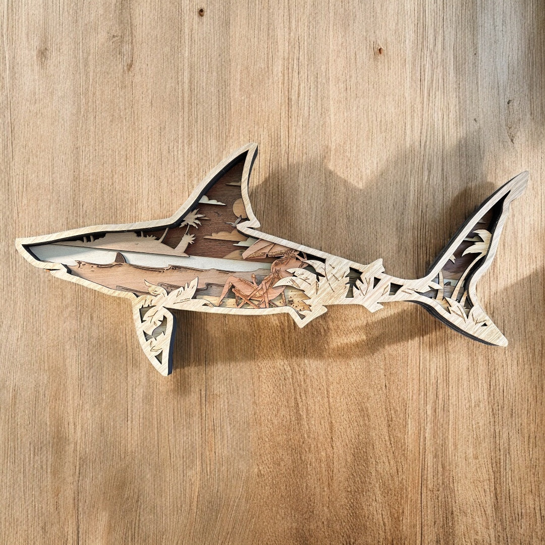 layered wooden shark that showcases a beach scene inside 