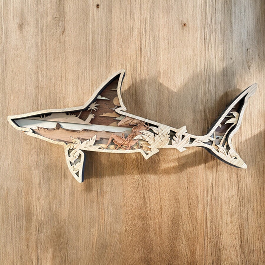 layered wooden shark that showcases a beach scene inside 