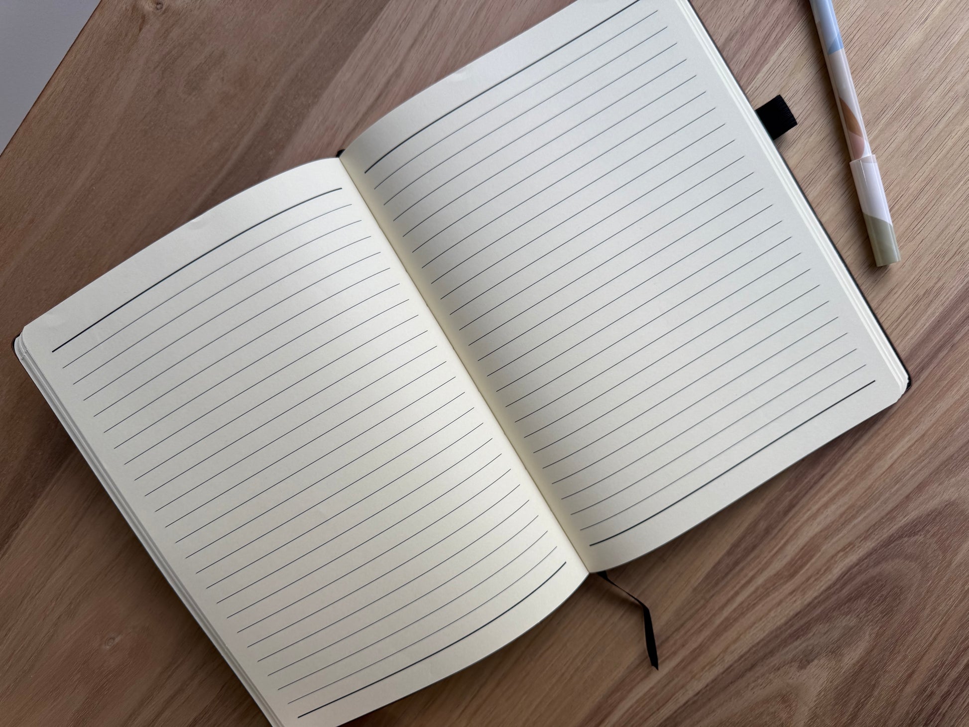 Open notebook with lined pages on a wooden surface